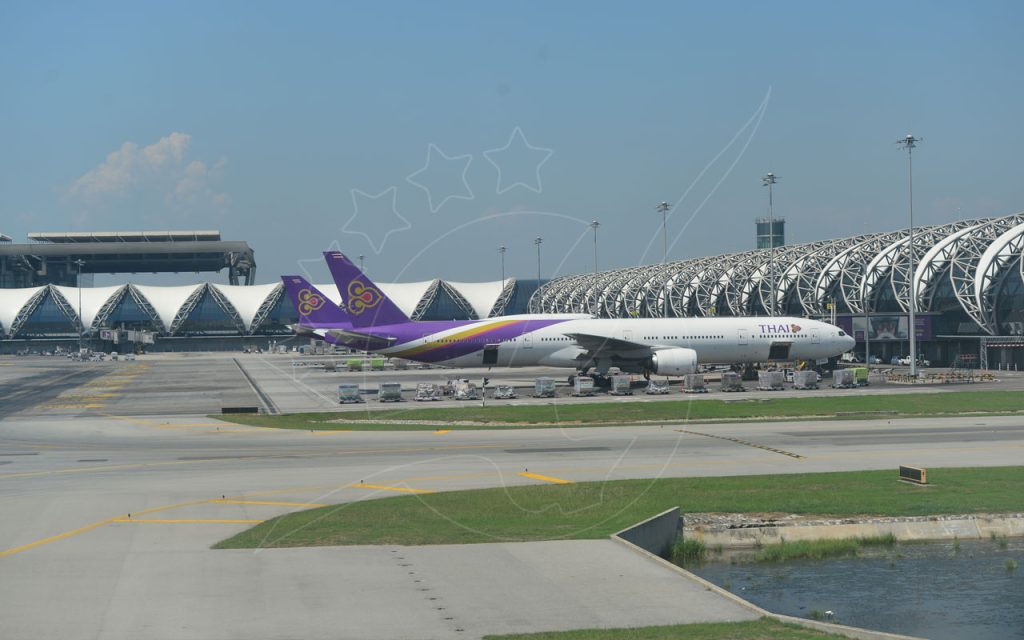 Avion gros-porteur de Thai Airways stationné au terminal de l'aéroport de Suvarnabhumi à Bangkok sous un ciel bleu